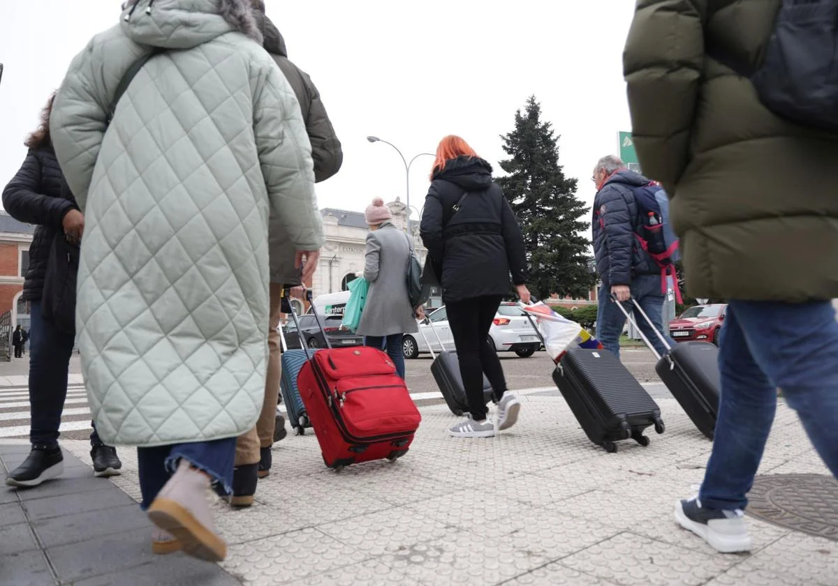 Varias personas con maletas, camino de la estación de ferrocarril. Rodrigo Jiménez