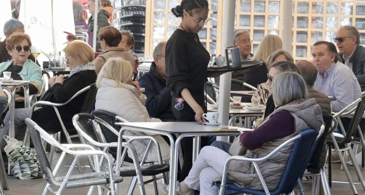 Una camarera sirve a una pareja en una terraza de la Plaza Mayor de Valladolid. Carlos Espeso